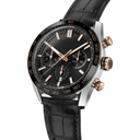Chronograph watch with black dial, rose gold accents, and black leather strap on white background
